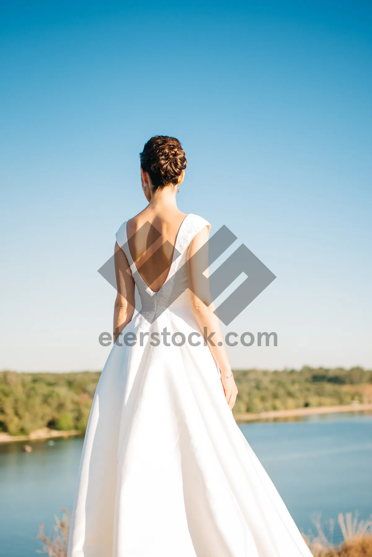 Picture of Attractive brunette bride smiles in elegant wedding dress.