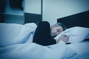 Man relaxing on a cozy sofa in bedroom.