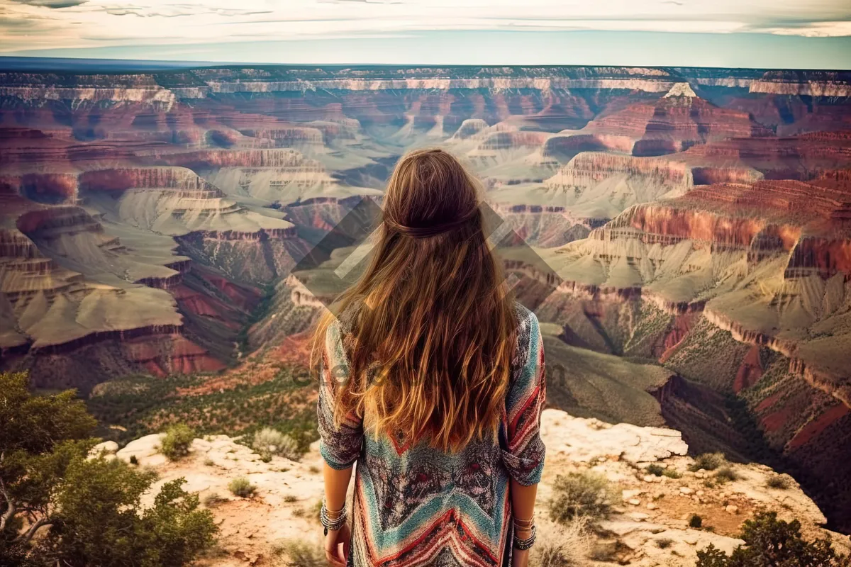 Picture of Tourist overlooking Grand Canyon in orange skirt.