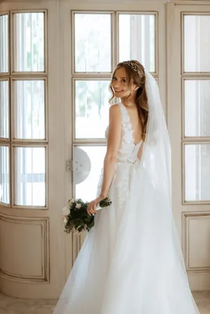 Brunette bride in elegant wedding gown smiling happily.