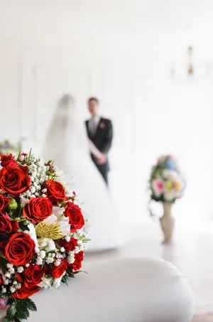 Attractive happy bride with bouquet of roses