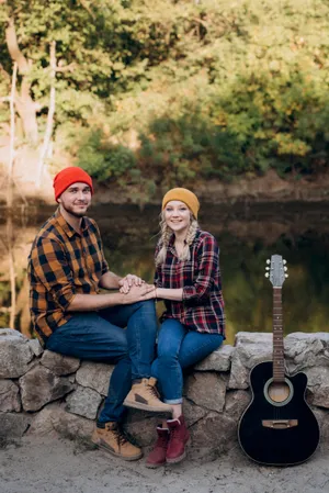 Happy couple hiking in autumn park with backpack