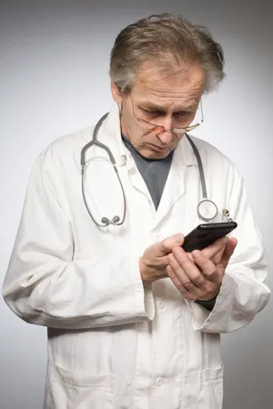 Happy male doctor with stethoscope in hospital.