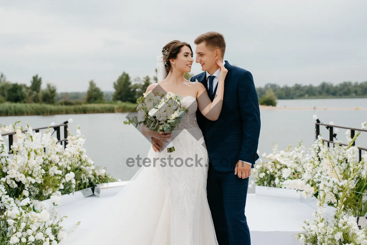 Picture of Happy newlywed couple celebrating love outdoors with flowers