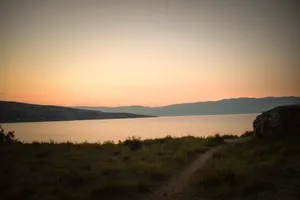 Sunset over mountain landscape with fields and trees