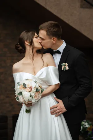 Celebrating couple in wedding attire with bouquet.