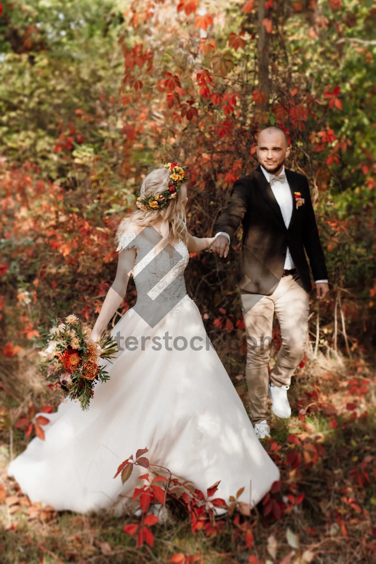 Picture of Wedding couple happily celebrating with bouquet of flowers