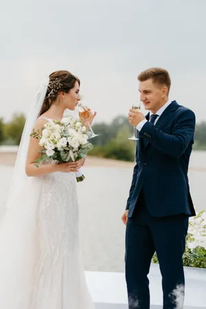 Happy couple celebrating their marriage with flower bouquet.