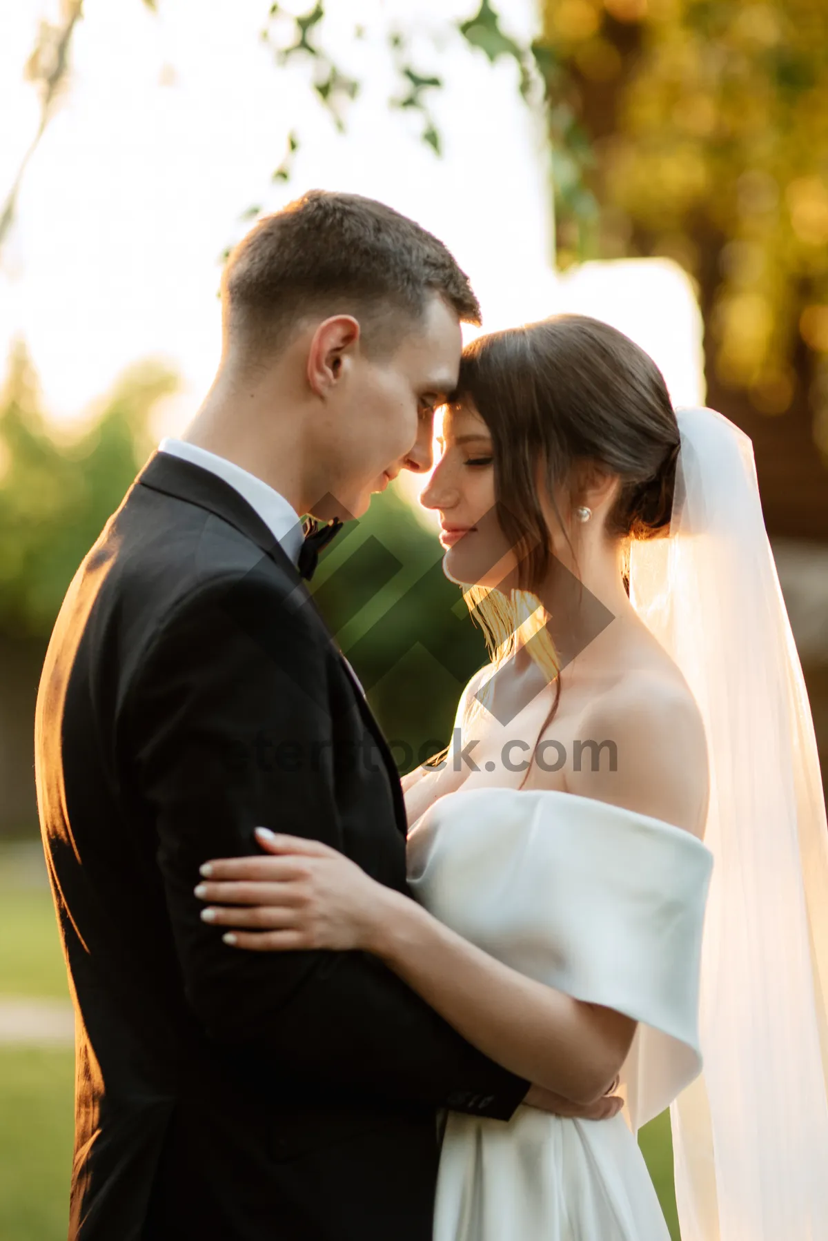 Picture of Happy couple outdoors in wedding attire smiling happily.