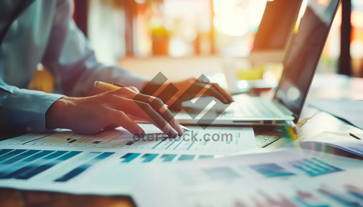 Picture of Busy businessman working on laptop at office desk