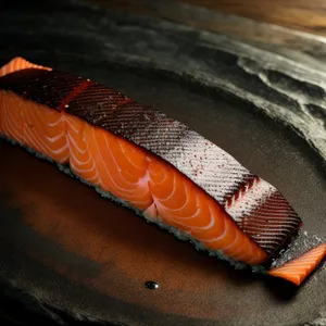Knife blade and salmon on cutting board