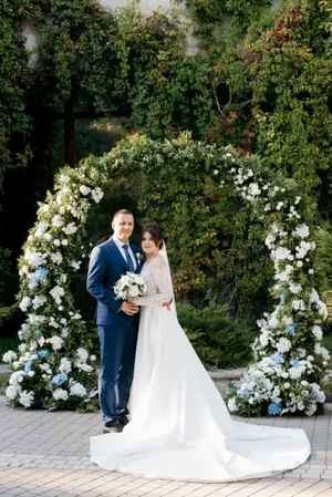 Happy wedding couple smiling outdoors with flowers.