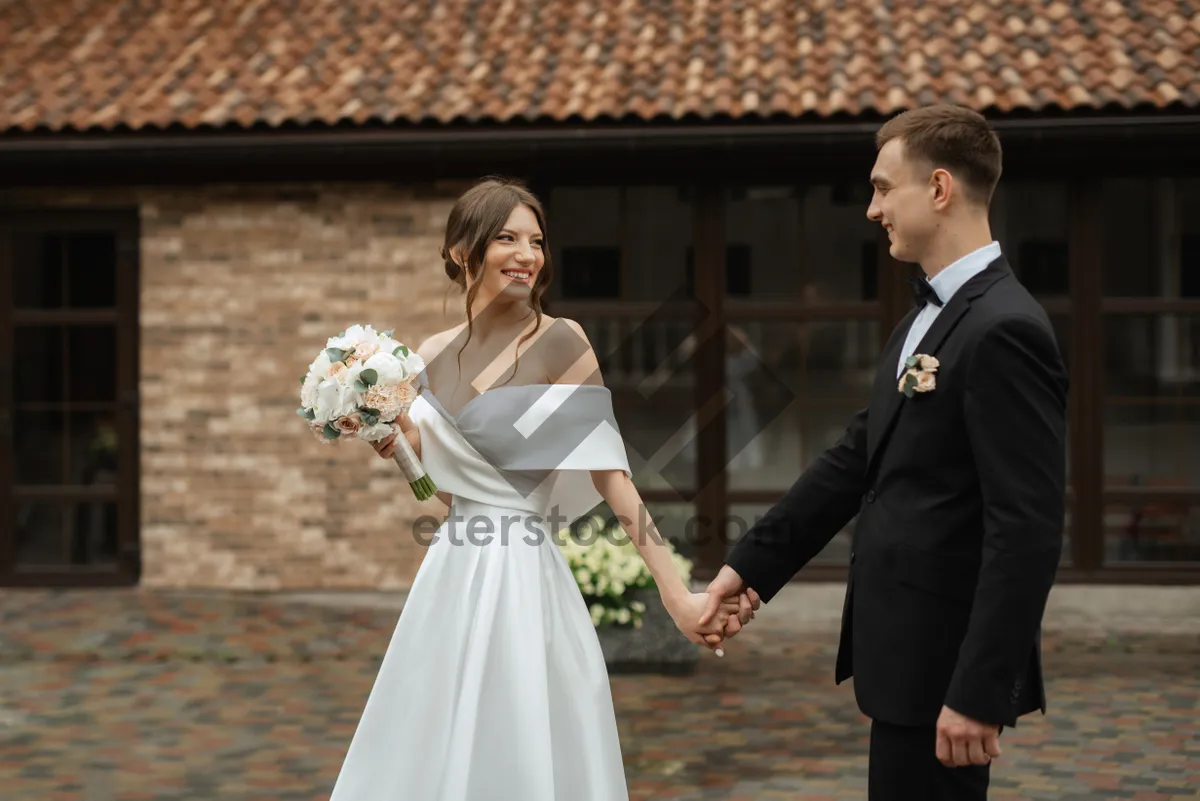 Picture of Happy Wedding Couple Smiling with Flowers Bouquet