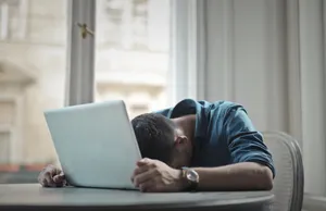 Happy businessman working on laptop in home office