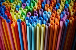 Colorful row of art supplies on wooden desk.