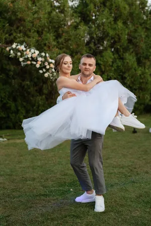 Happy newlywed couple embracing outdoors on wedding day