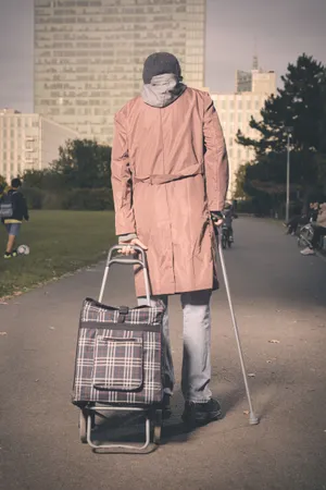 Man with crutch playing golf on grass.