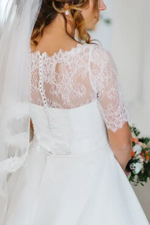 Attractive bride in a wedding gown holding bouquet