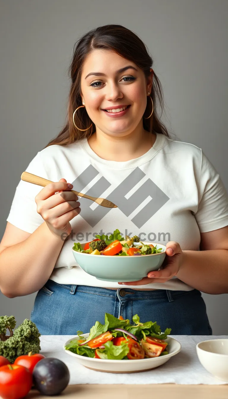 Picture of Attractive adult enjoying a fresh vegetable salad meal.