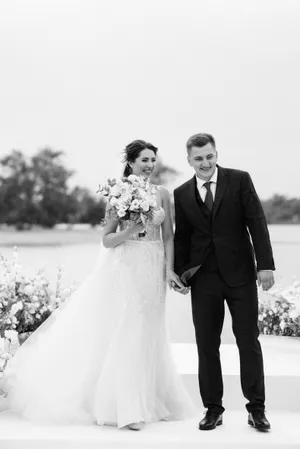 Happy Newlywed Couple Celebrating Wedding Outdoors with Flowers