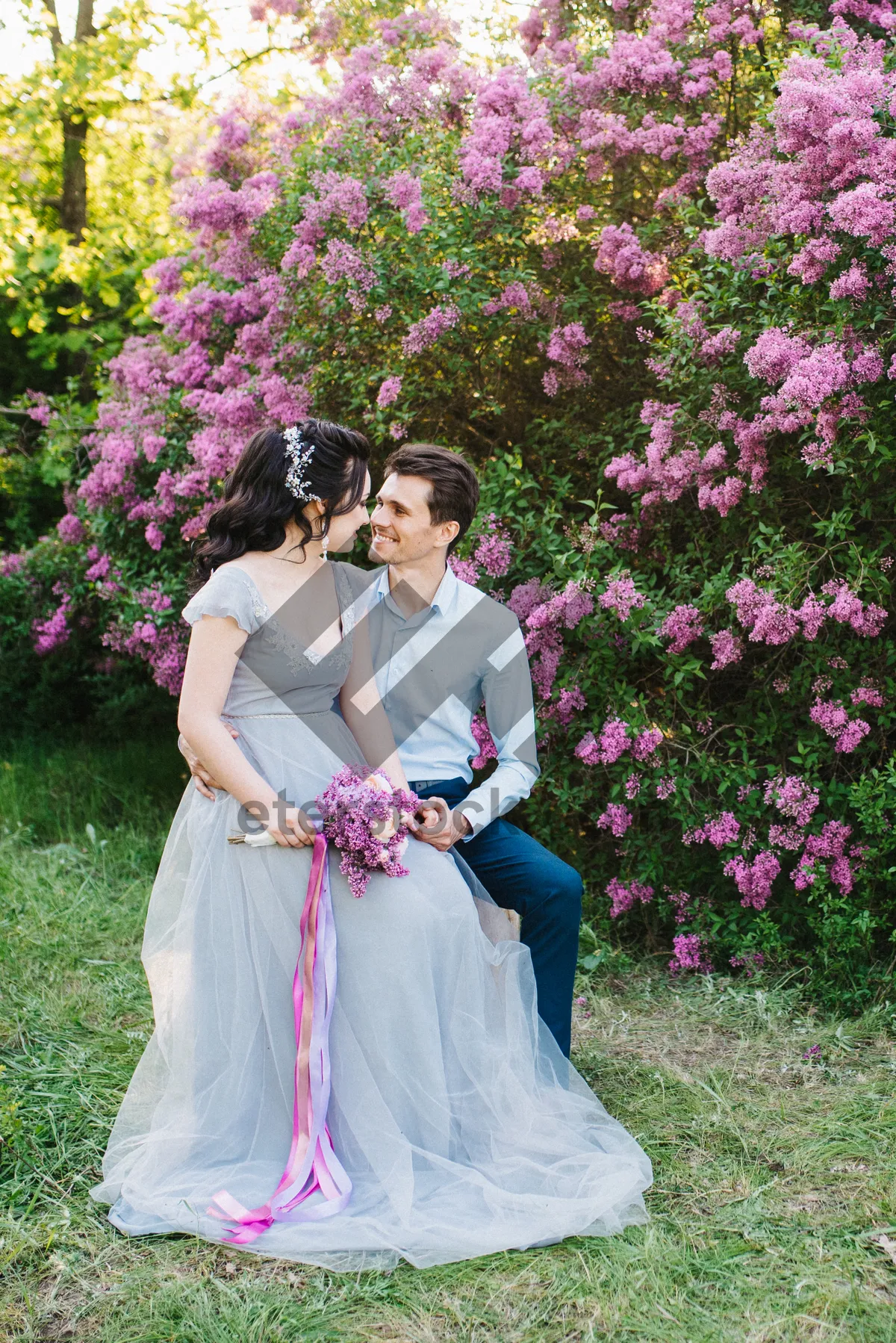 Picture of Happy bride and groom surrounded by flowers in garden.