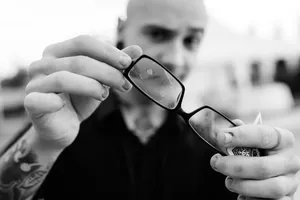 Attractive business man in sunglasses holding phone.