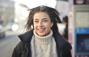 Smiling brunette lady wearing scarf with phone