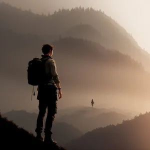 Male Hiker Conquering Mountain Summit at Sunset