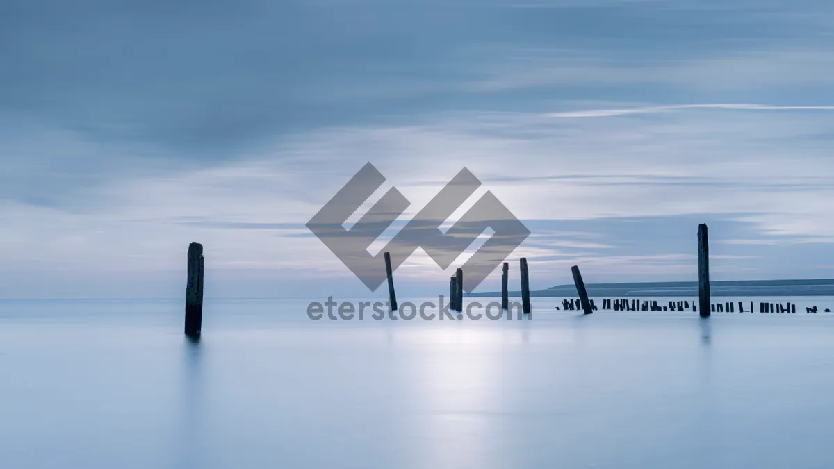 Picture of City skyline reflecting in water during sunset.