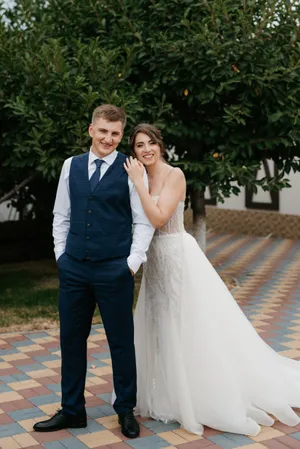 Romantic wedding couple smiling happily outdoors surrounded by flowers