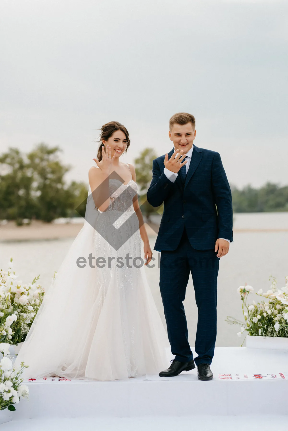 Picture of Happy newlywed couple celebrating wedding day outdoors.