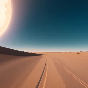 Sunset Drive through Desert Expanse: Tranquil Road with Vast Sand Dunes