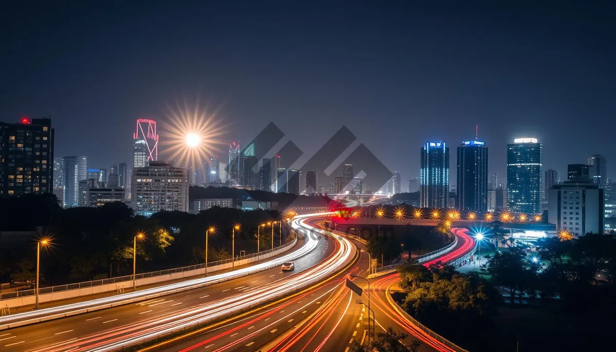 Picture of Cityscape with blurred car lights on highway at night.