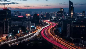 Modern city skyline with bridge, river, and traffic.