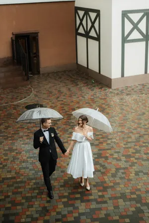 Happy adult under protective umbrella in rain