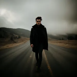 Silhouette of a man in trench coat at sunset