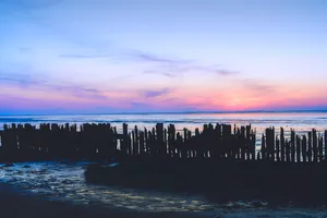 Ocean sunset waves on beach shore.