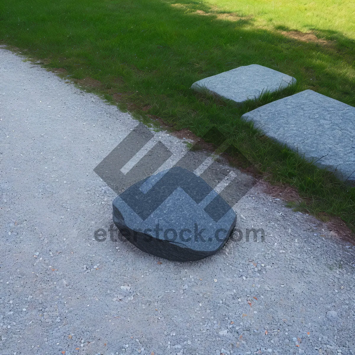 Picture of Stone Manhole Cover on Top of Sand-Covered Road