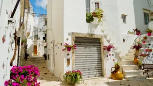 Old stone house with balcony and flowers in town