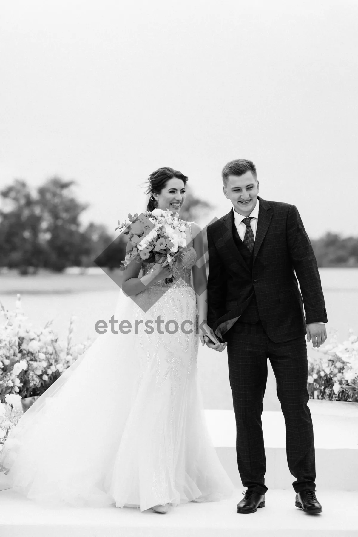 Picture of Happy Newlywed Couple Celebrating Wedding Outdoors with Flowers