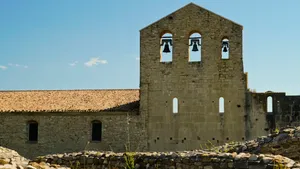 Medieval castle with bell tower and stone walls.