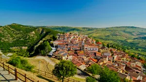 Scenic town with castle on hill overlooking river.