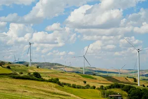 Wind turbine generating power in rural countryside field