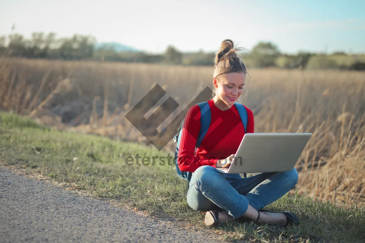 Picture of Happy boy with laptop in park on sunny day.