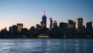 Modern skyline at dusk with bustling waterfront cityscape.