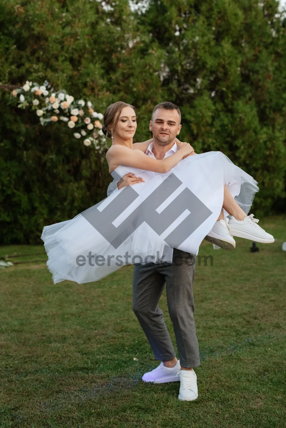 Picture of Happy newlywed couple embracing outdoors on wedding day