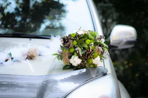 Wedding Couple in Decorated Car with Flower Bouquet