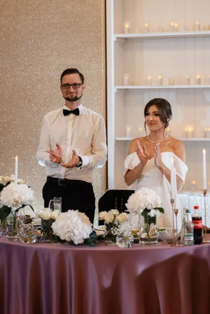 Happy newlyweds with bouquet at wedding celebration.