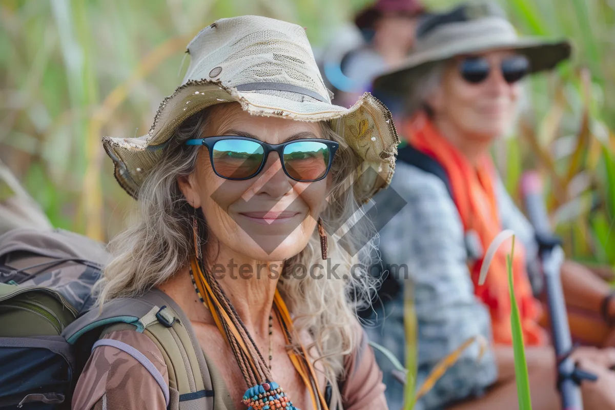 Picture of Attractive man smiling in sunglasses and hat outdoors.