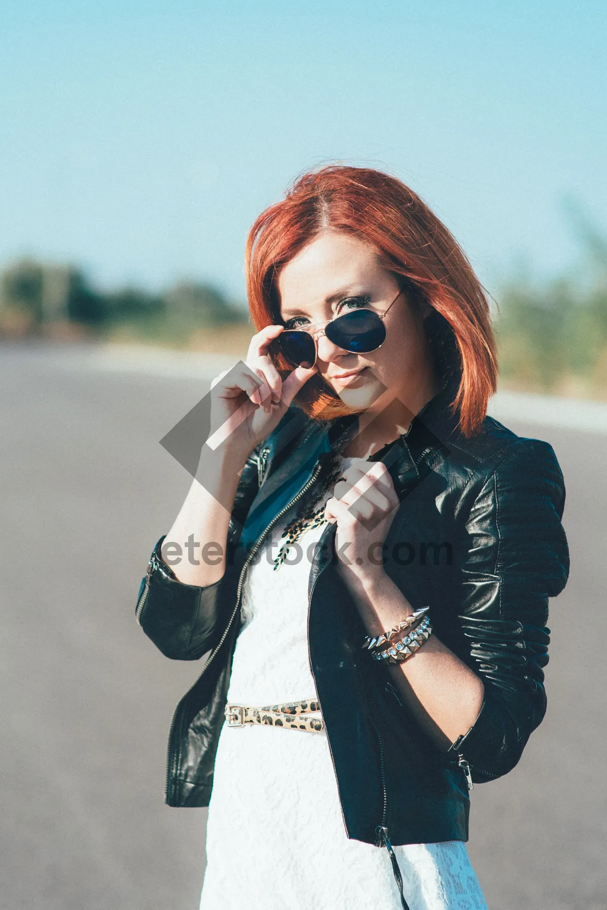 Picture of Attractive singer in sunglasses talking on phone.